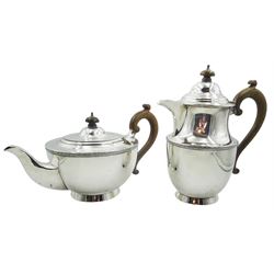 1920's silver teapot and hot water pot, each with foliate scroll band to body and stained wooden handle and finial, hallmarked William Neale & Son Ltd, Birmingham 1923 and 1924, including handle teapot H14.5cm hot water pot H20.5cm approximate total gross weight 32.17 ozt (1000.7 grams)