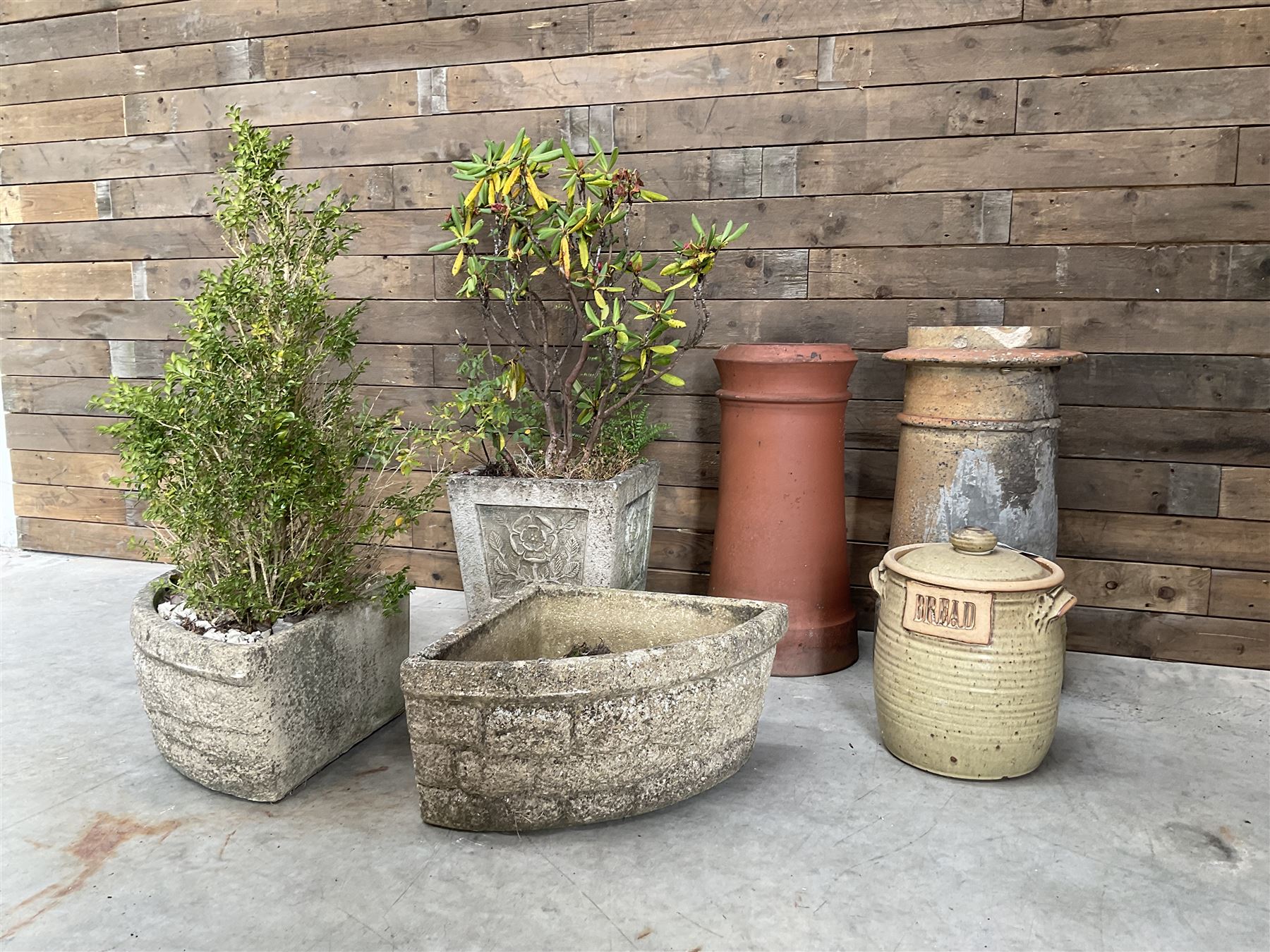 Two cast stone corner planters, square planter other Yorkshire Rose, two terracotta chimney pots and a terracotta bread bin (6)