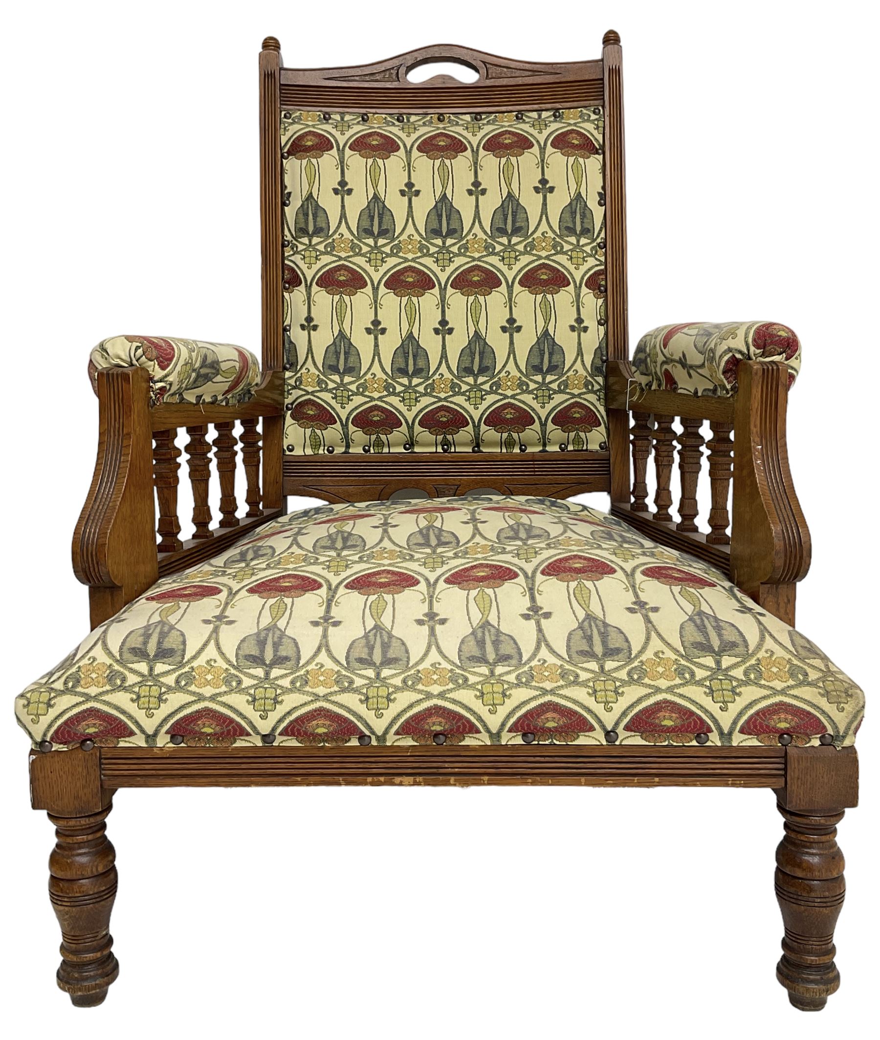 Early 20th century armchair, back and sprung seat upholstered in Art Nouveau patterned fabric, raised on ring turned supports, the frame with all-over reeded decoration