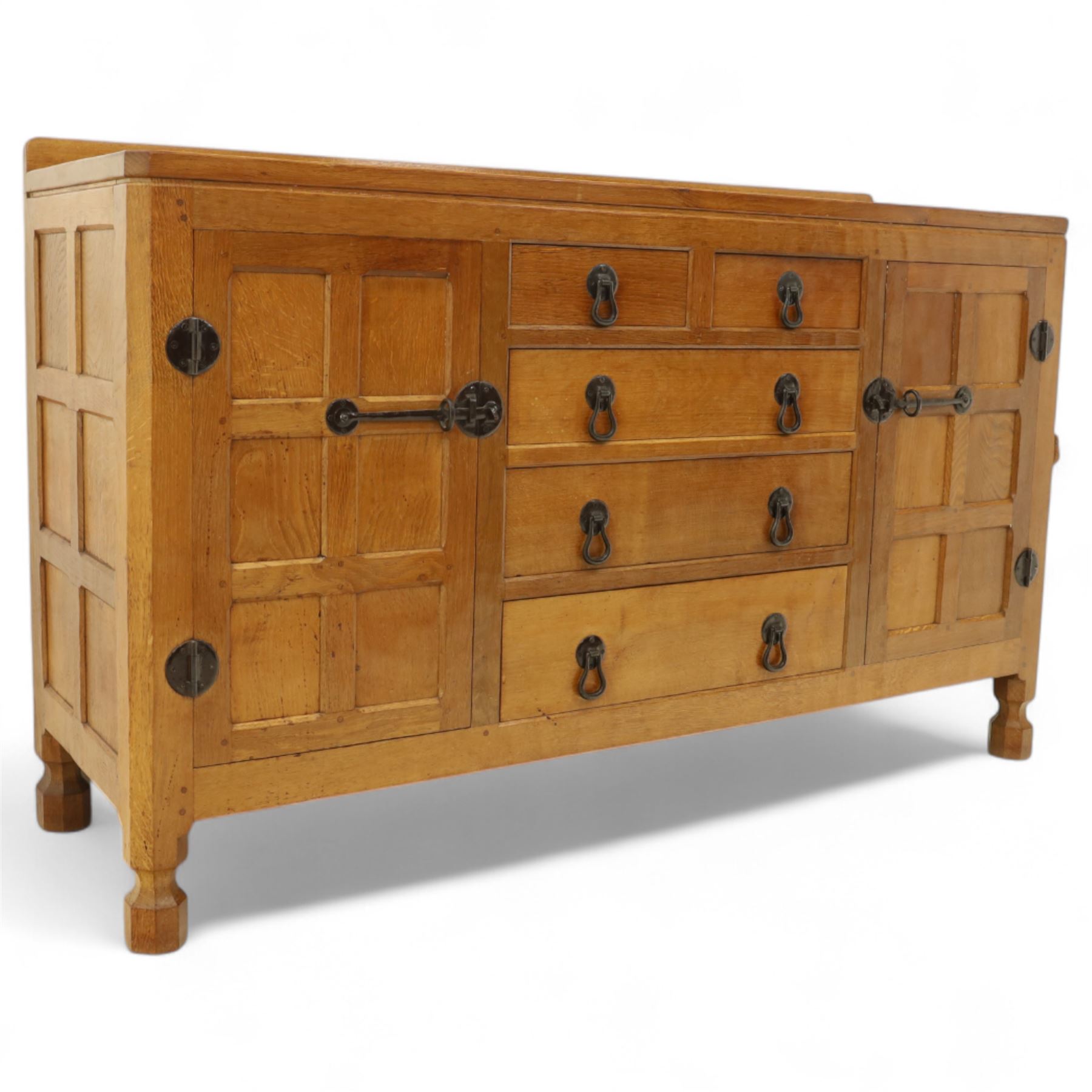 Mouseman - oak sideboard with adzed top and raised gallery back, over two short drawers and three long drawers, flanked by panelled cupboard doors with wrought iron fittings, on octagonal feet, carved with the signature mouse to the right-hand door