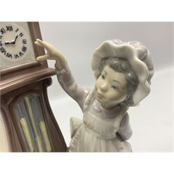 Lladro figure, Bedtime, modelled as a young girl reaching for her pet cat upon grandfather clock, sculpted by Vincente Martinez, with original box, no 5347, year issued 1986, year retired 1998, H28cm