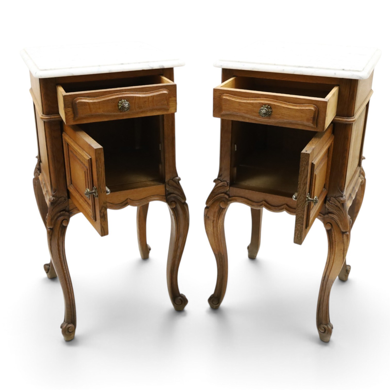 Pair of 20th century French honey oak and marble bedside cabinets, the square marble top with moulded edge, fitted with single drawer over panelled cupboard, shaped and moulded apron over scrolling acanthus leaf applied knees terminating to cabriole legs with scroll feet