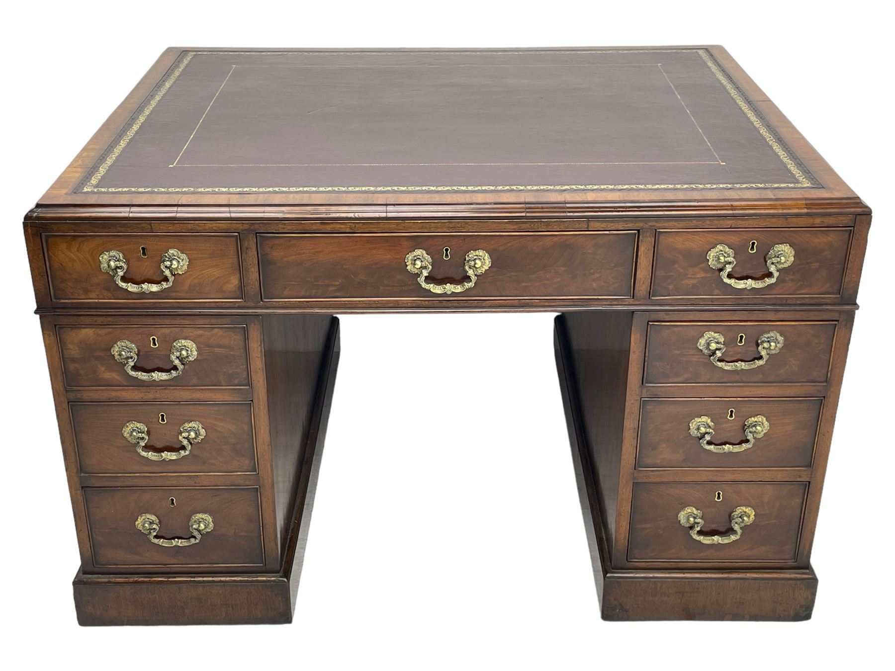 George III mahogany twin pedestal partner's desk, moulded rectangular caddy top with tooled leather inset, one side fitted with nine drawers and the opposing side fitted with single drawer, two false drawers and two panelled cupboards, ornate cast gilt metal handles and handle plates, on plinth base