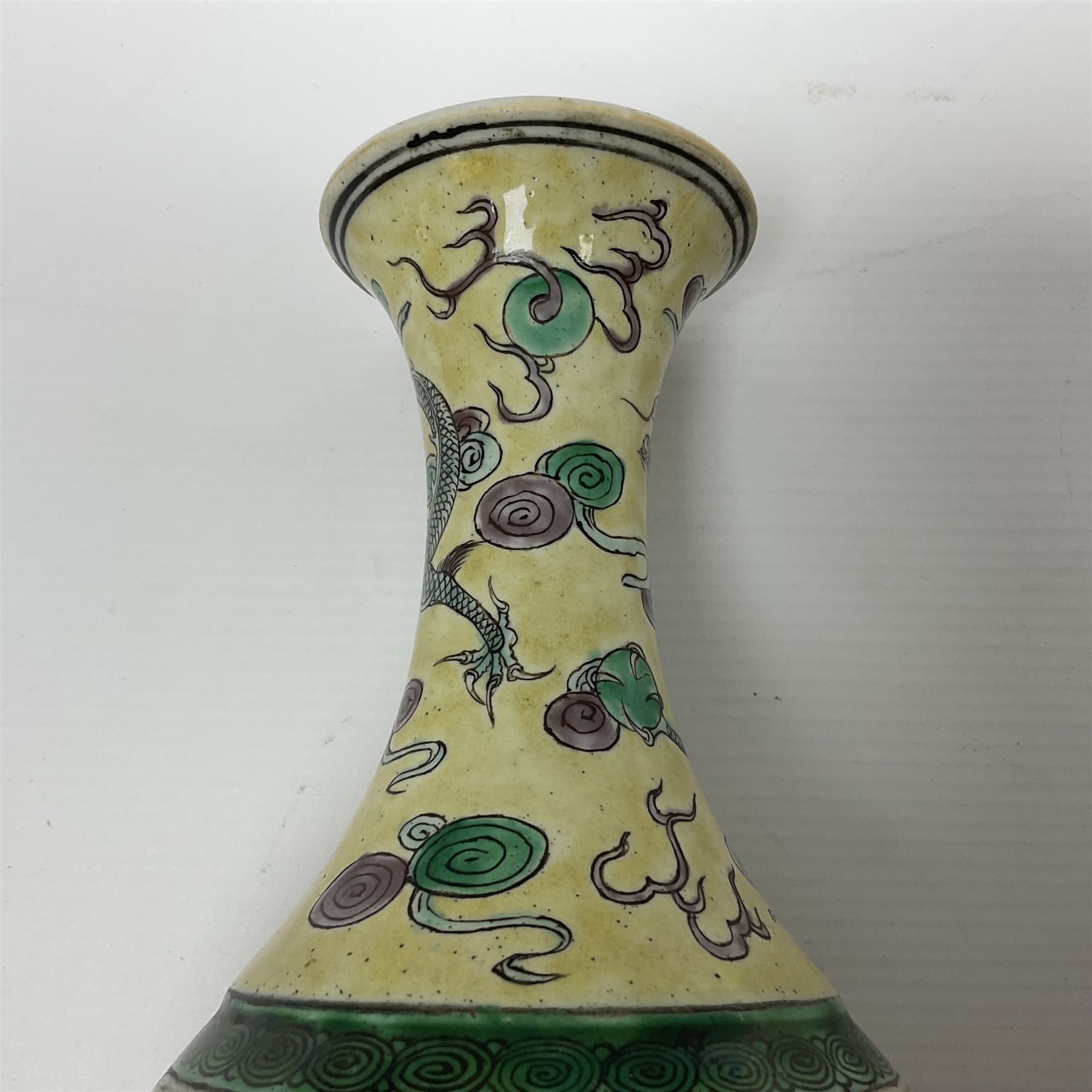 20th century Chinese Famille Verte vase, of slender ovoid form with tapering neck and flared rim, decorated with green and grey enamel with dragons chasing flaming pearls amongst auspicious clouds upon a yellow ground, H30cm