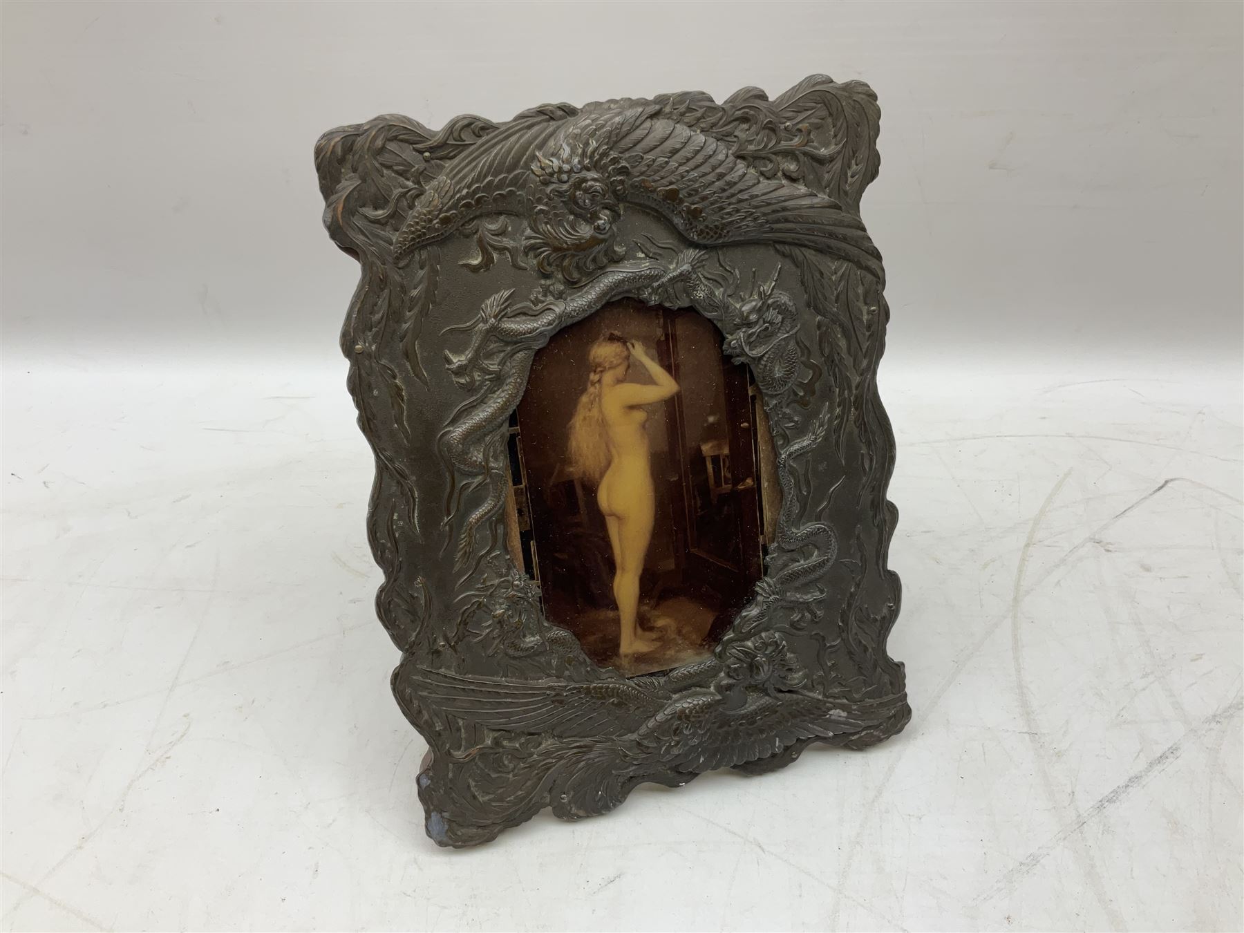 Japanese bronzed antimony frame, decorated with dragons and ho ho birds, easel stand to reverse, containing Continental crystoleum of female nude, H24cm