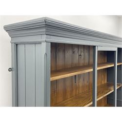 Painted pine open bookcase, projecting cornice and panelled sides, four fixed shelves, raised on platform 