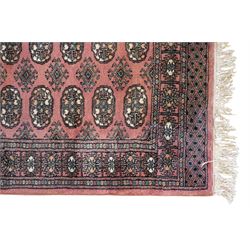 Afghan pale red ground runner, the field decorated with two rows of Gul motifs, within repeating patterned border