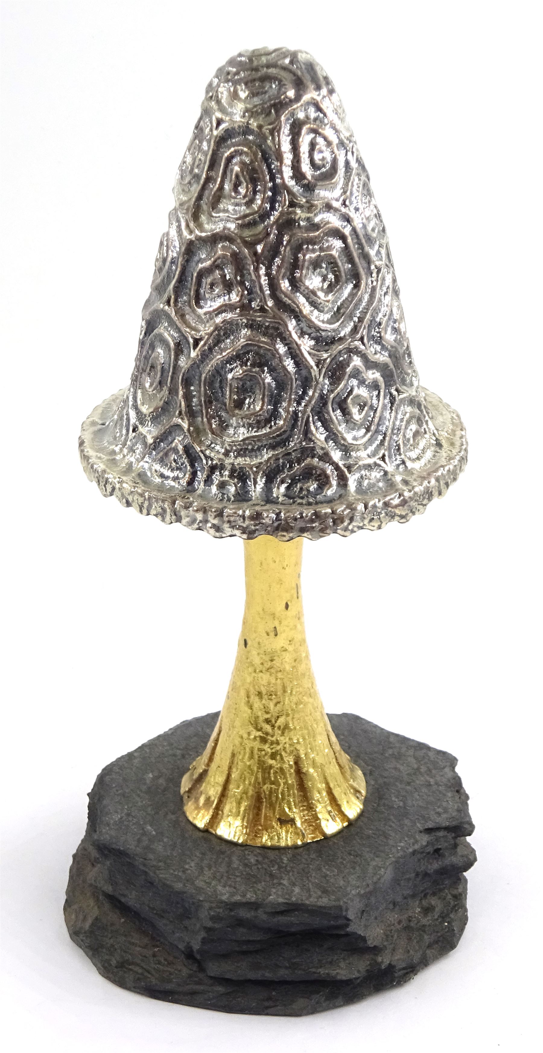 Christopher Nigel Lawrence limited edition silver and parcel gilt surprise mushroom, the textured domed cover opening to reveal two elves carolling beneath a lantern and before a fire pit set with semi-precious stones, upon a slate base, no 24/250, hallmarked Christopher Nigel Lawrence, London 1982, overall H9cm