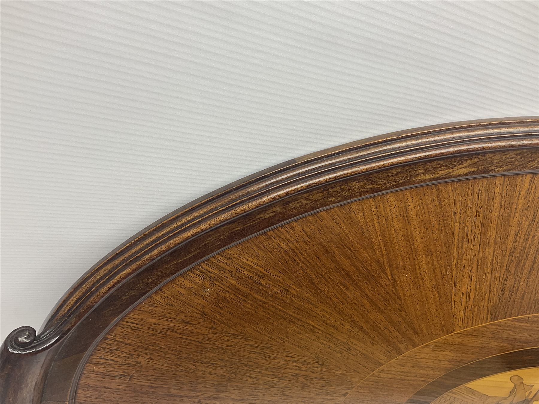 Late 19th/early 20th century mahogany and marquetry inlaid tray, of oval form with twin scrolled handles and moulded border, the central panel inlaid with figures seated at a table drinking tea, L99cm