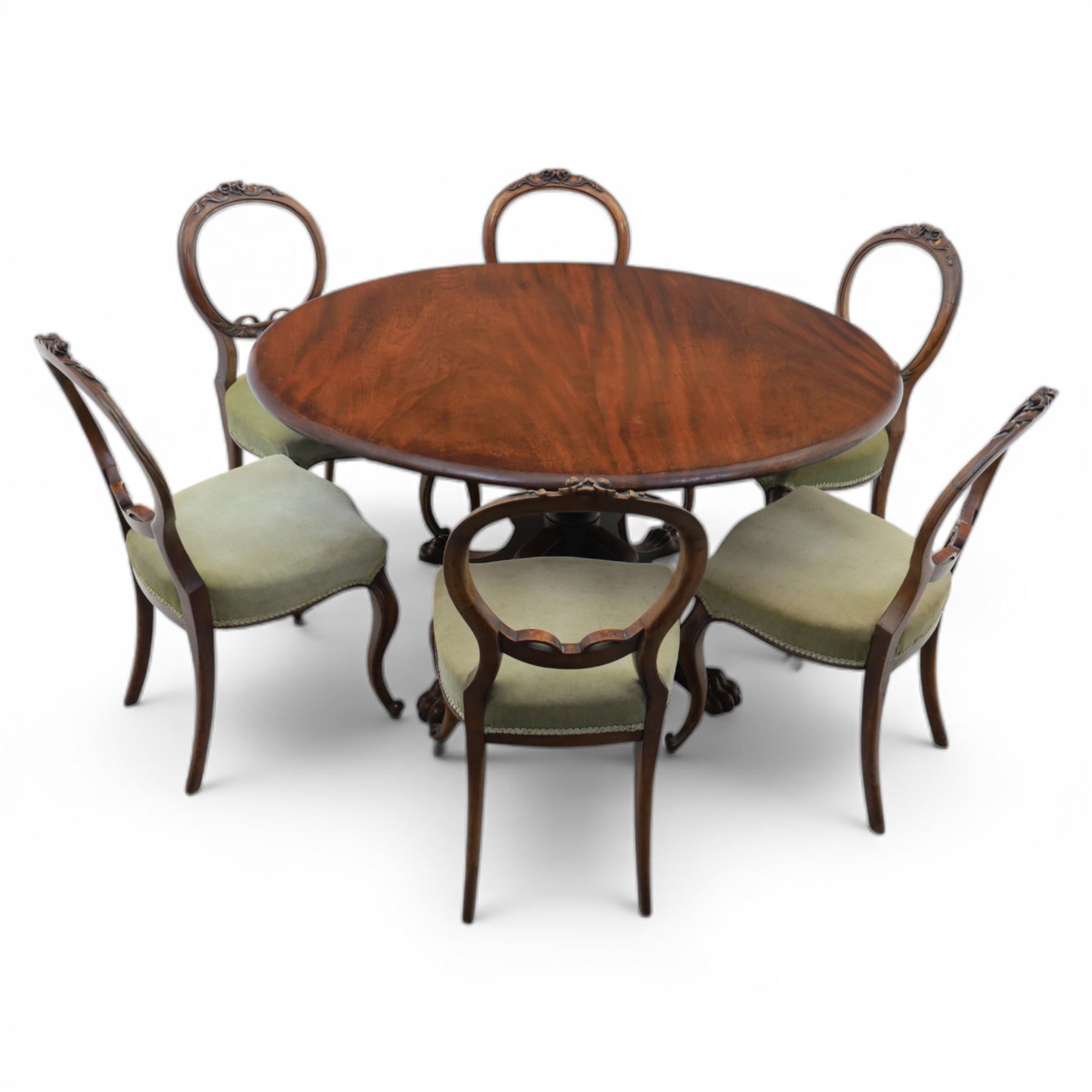 Victorian mahogany dining suite, oval tilt top dining table raised on a quatriform base with paw feet, together with a set of six balloon back dining chairs with green upholstery with cabriole legs 