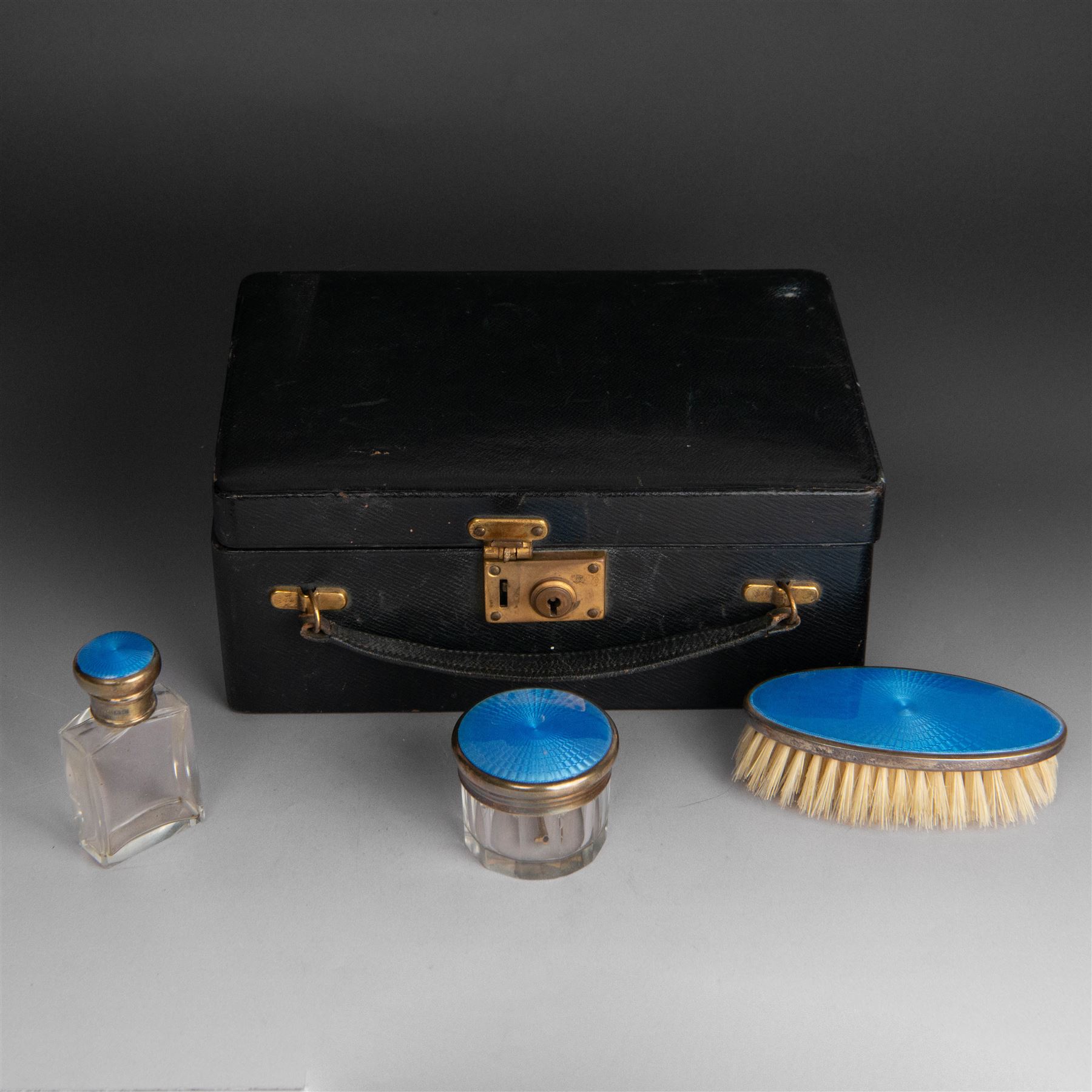 1920s silver mounted blue guilloche enamel travelling dressing table set, comprising hairbrush, comb, bottle and jar, hallmarked RWF Ltd, Birmingham 1927, contained withing tooled leather fitted case with bevelled mirror to interior