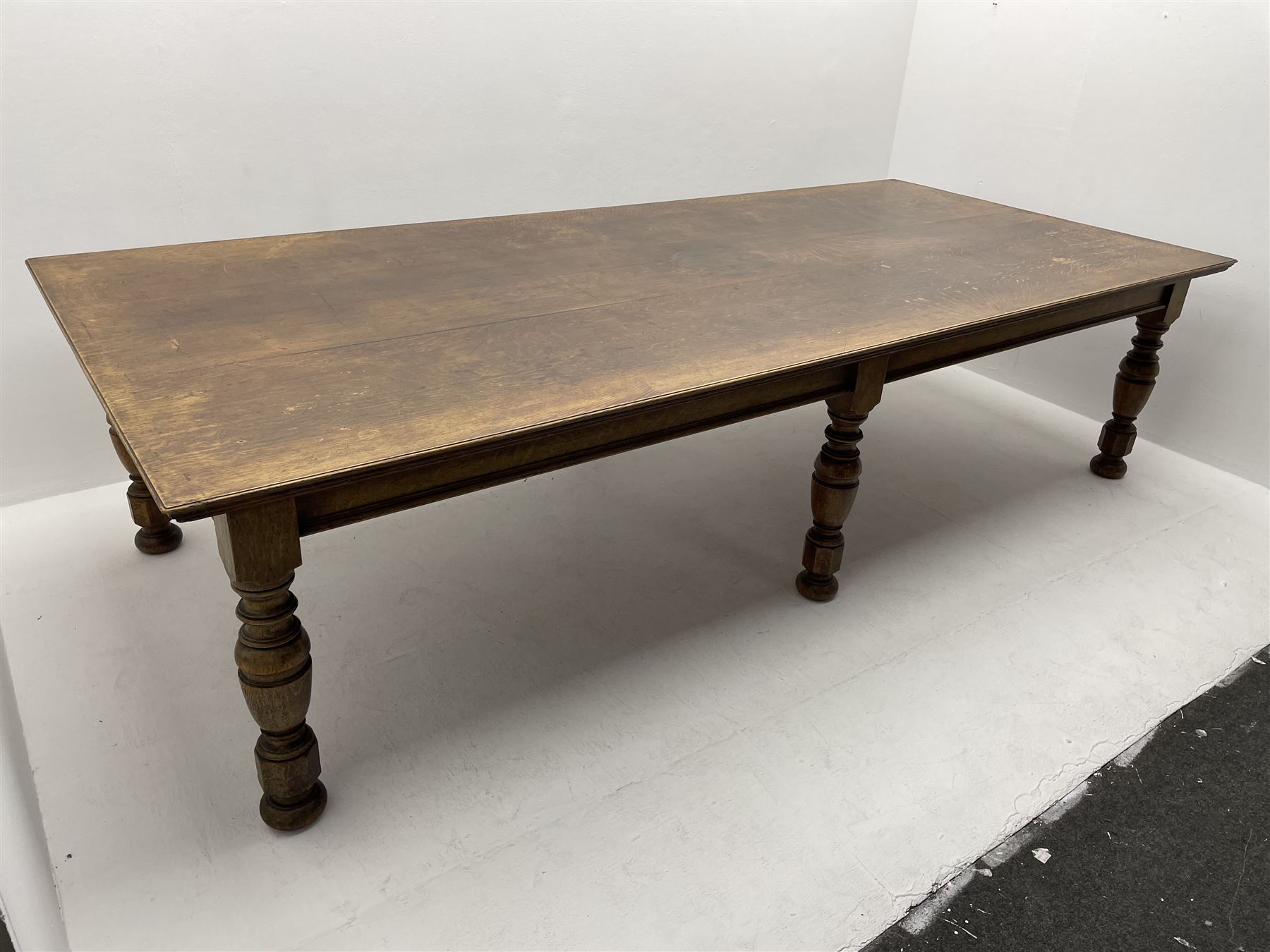 Large early 20th century oak boardroom table, rectangular moulded top on six turned and faceted supports 