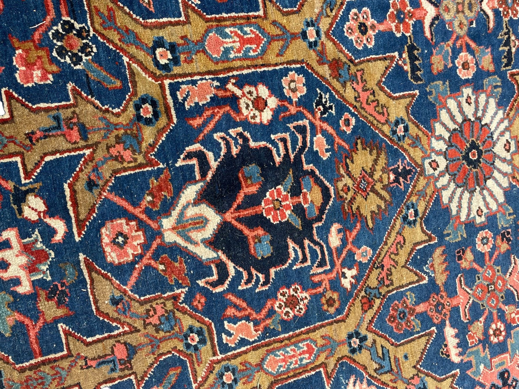 Persian blue ground carpet, the field divided up into panels by trailing bands with flower heads, each panel decorated with palmettes and stylised plant motifs, the border decorated with further palmettes, within floral pattern guard stripes 