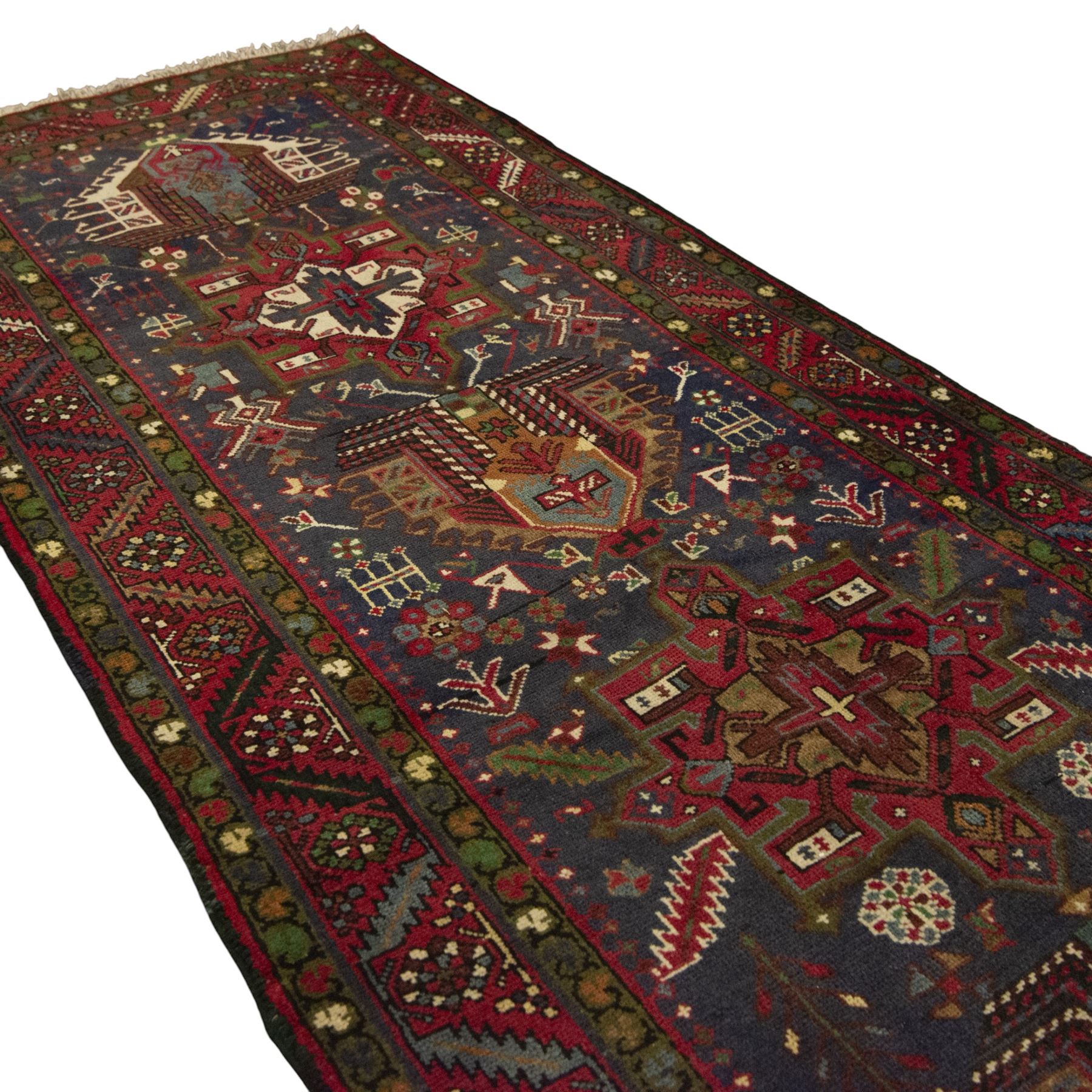Large Northwestern Persian Hamadan hand-knotted runner, indigo field, with a column of bold geometric medallions and scattered stylized motifs within a madder border of angular rosettes and meandering vines 