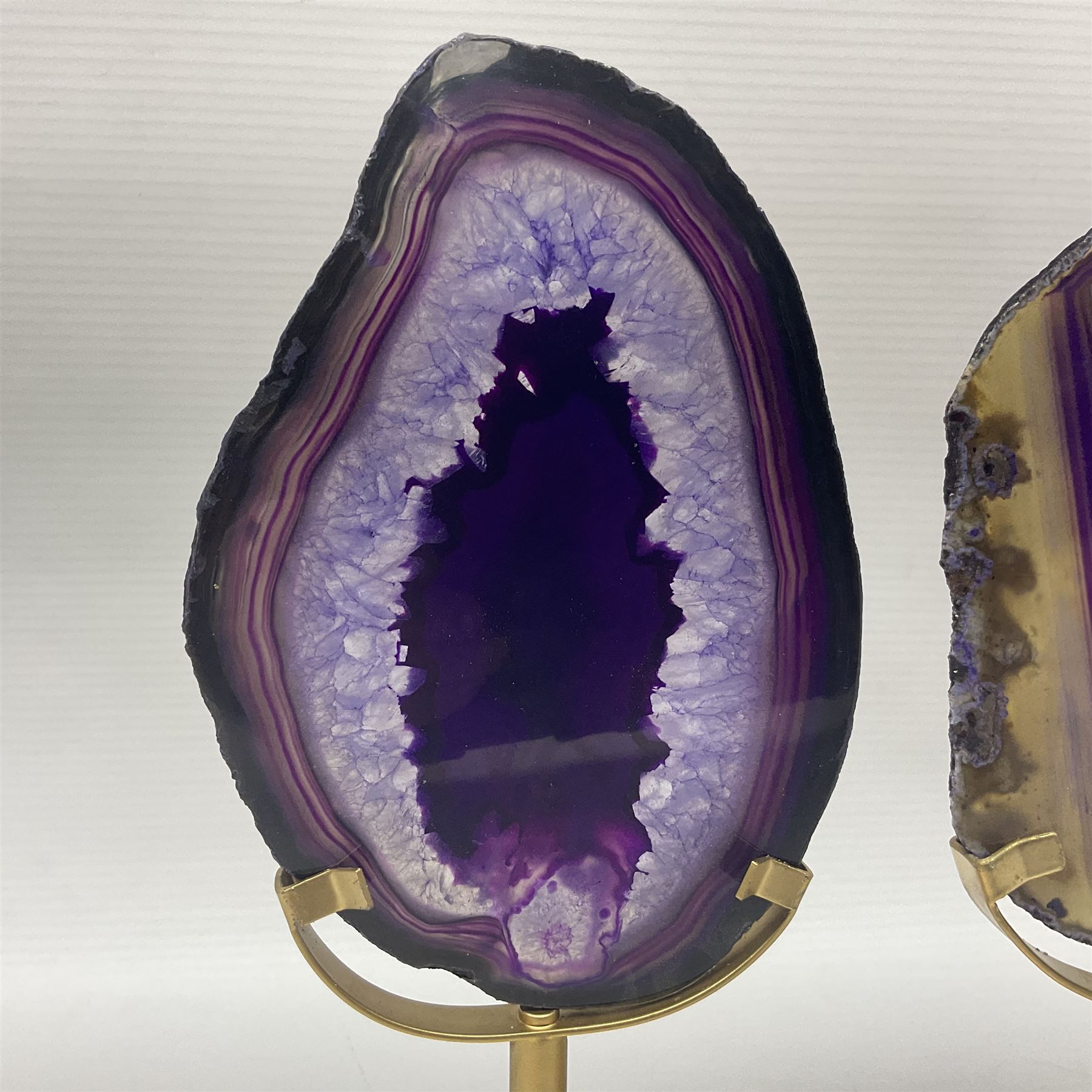 Pair of purple agate slices, polished with rough edges raised upon gilt metal stands