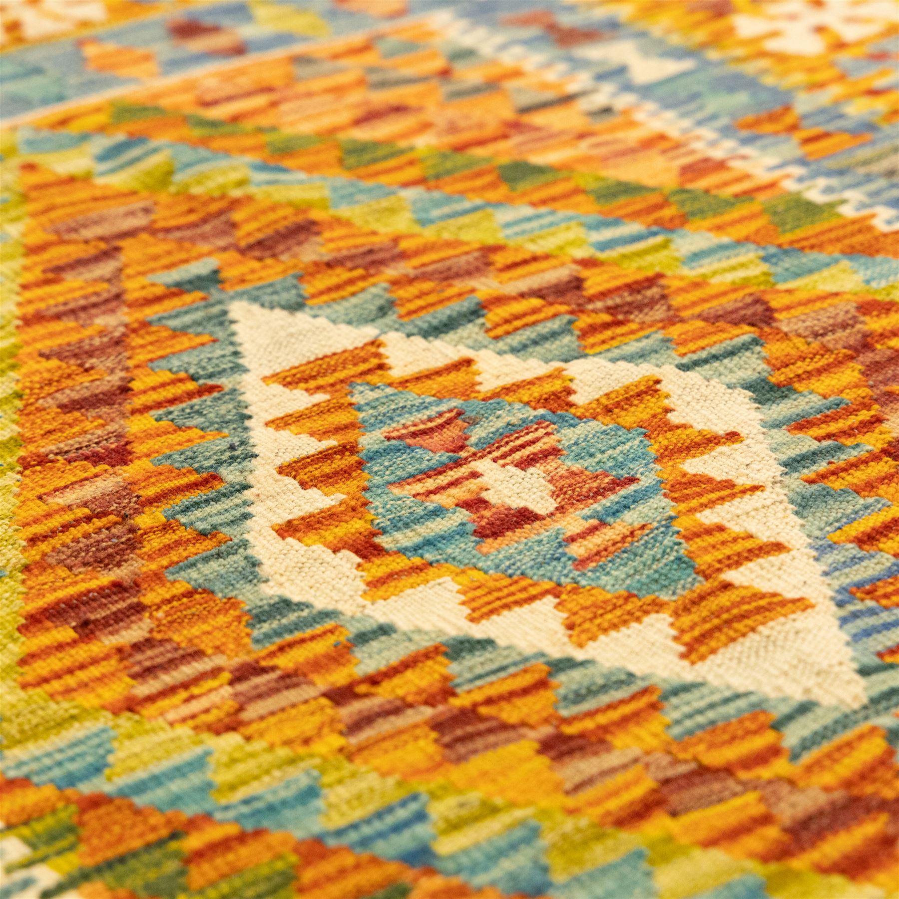 Two Chobi Kilim flatweave rugs, comprising the largest kilim on a cream ground with a grid of stepped diamond medallions in a palette of rust red, turquoise, green, ochre, and lilac,, filled lozenge motifs, framed by a cream ground border, 148x101cm, Chobi Kilim with multi-stepped diamond medallion with serrated bands, in terracotta, turquoise, green, saffron and blue, framed by a broad polychromed border of stylized guls and narrow guard stripes, 114x87cm 