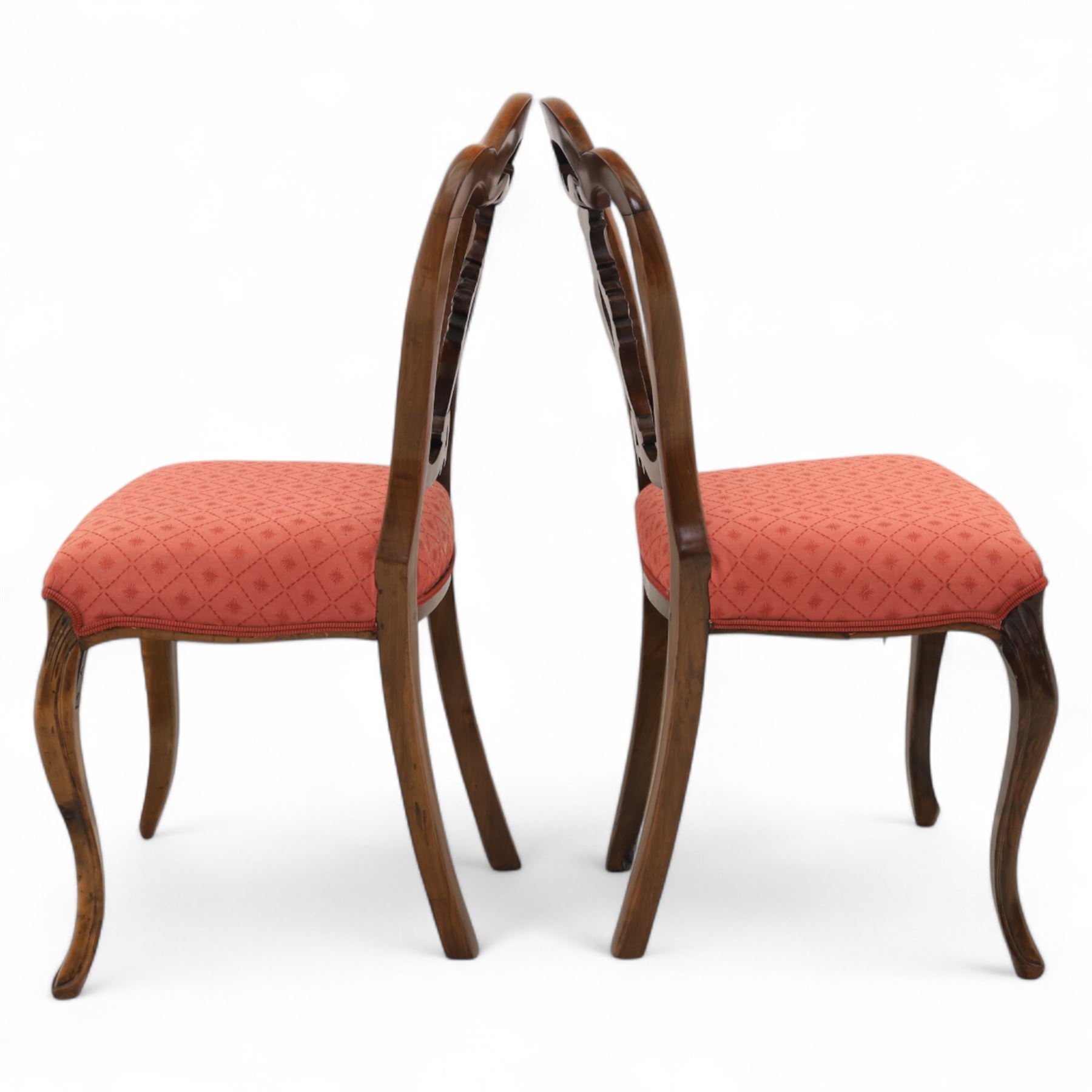 Set of four Victorian walnut balloon back chairs, with a carved and pierced back splat with foliate scrolls, serpentine seat upholstered in a diamond pattern fabric, raised on cabriole legs 