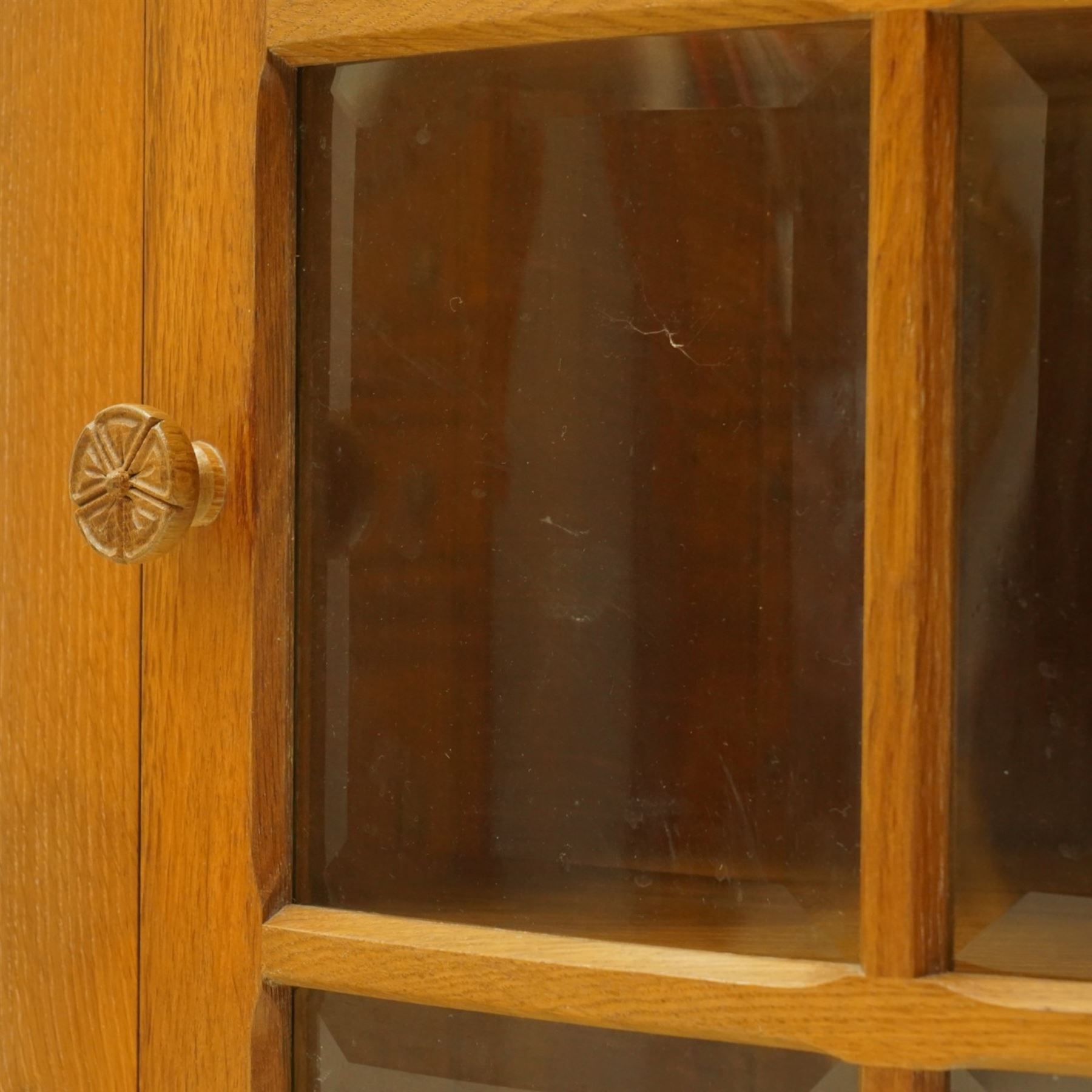 Beaverman - oak hanging corner cabinet, astragal glazed door with a Yorkshire Rose door pull, revealing two fixed shelves, brass mounts for hanging, with carved beaver signature, by Colin Almack of Sutton near Thirsk