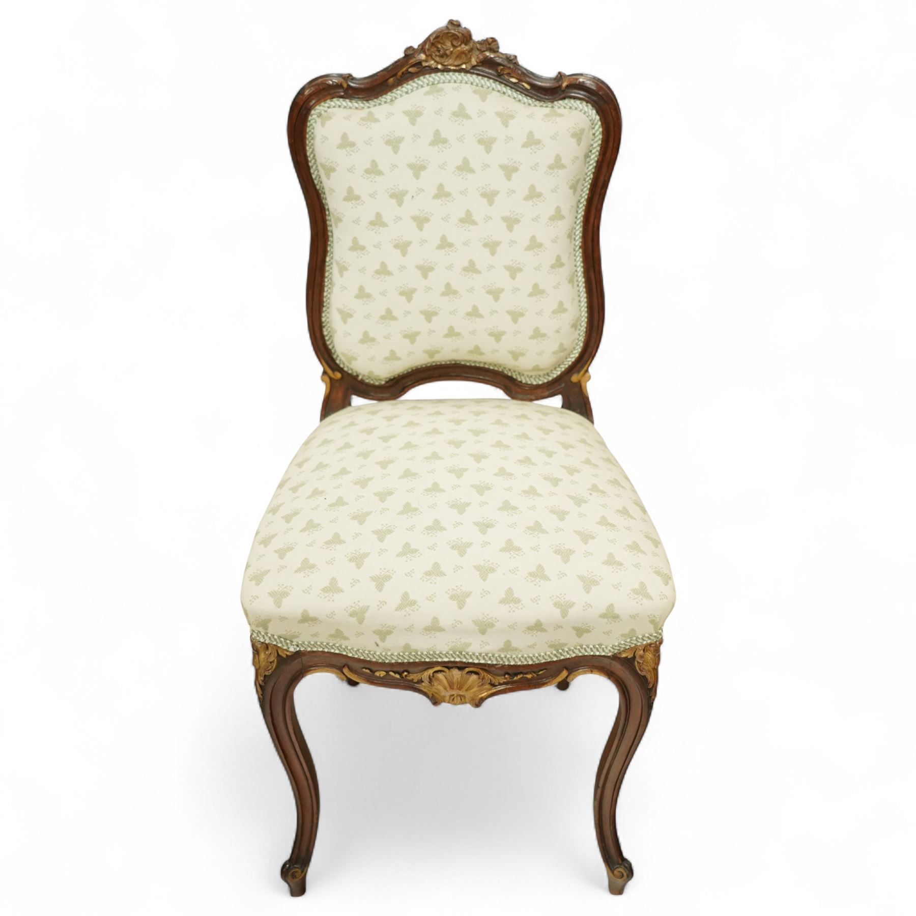 Louis XV design salon suite comprising a pair of walnut and parcel-gilt fauteuil armchairs together with a side chair, the cresting rail surmounted with a carved giltwood floral shell motif with extending foliage, the cartouche shaped backs and sprung seats upholstered in pale blue patterned fabric, over a shaped apron with scallop decoration and foliage carved knees, raised on cabriole supports