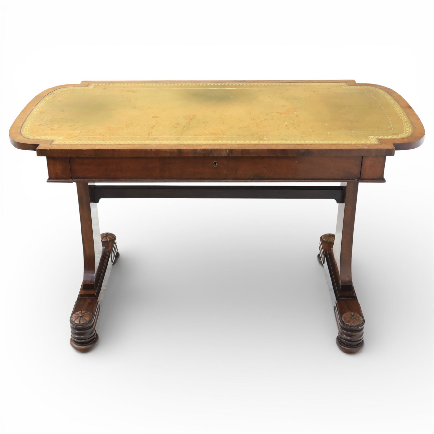 William IV mahogany library table, rectangular top with rounded edges inset with gilt and blind tooled leather writing surface, fitted with opposing frieze drawers, raised upon shaped trestle end supports united by a central upper stretcher, terminating in stylised bun feet with applied roundel bosses