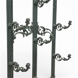 Late 19th century cast iron stick stand, the arched back with scrolling foliate decoration, fitted with multiple hooks, the lower section with pierced panels centred by a radiating sunburst motif, raised on a rectangular drip tray base