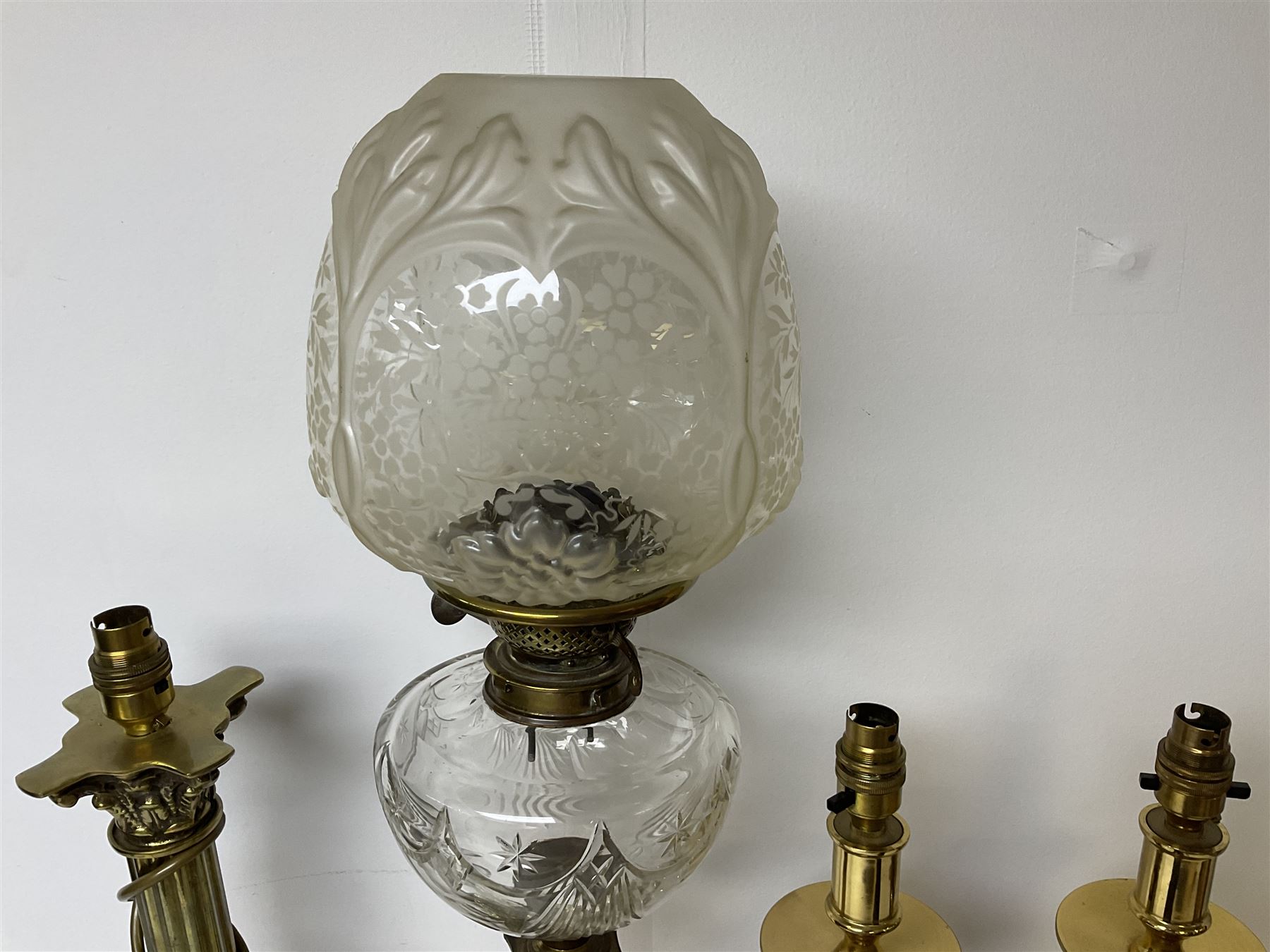 Oil lamp with frosted floral shade and cut glass reservoir, upon cast brass and marble base, together with a cast brass Corinthian column table lamp, pair of brass table lamps and a composite metal figure of a violinist 