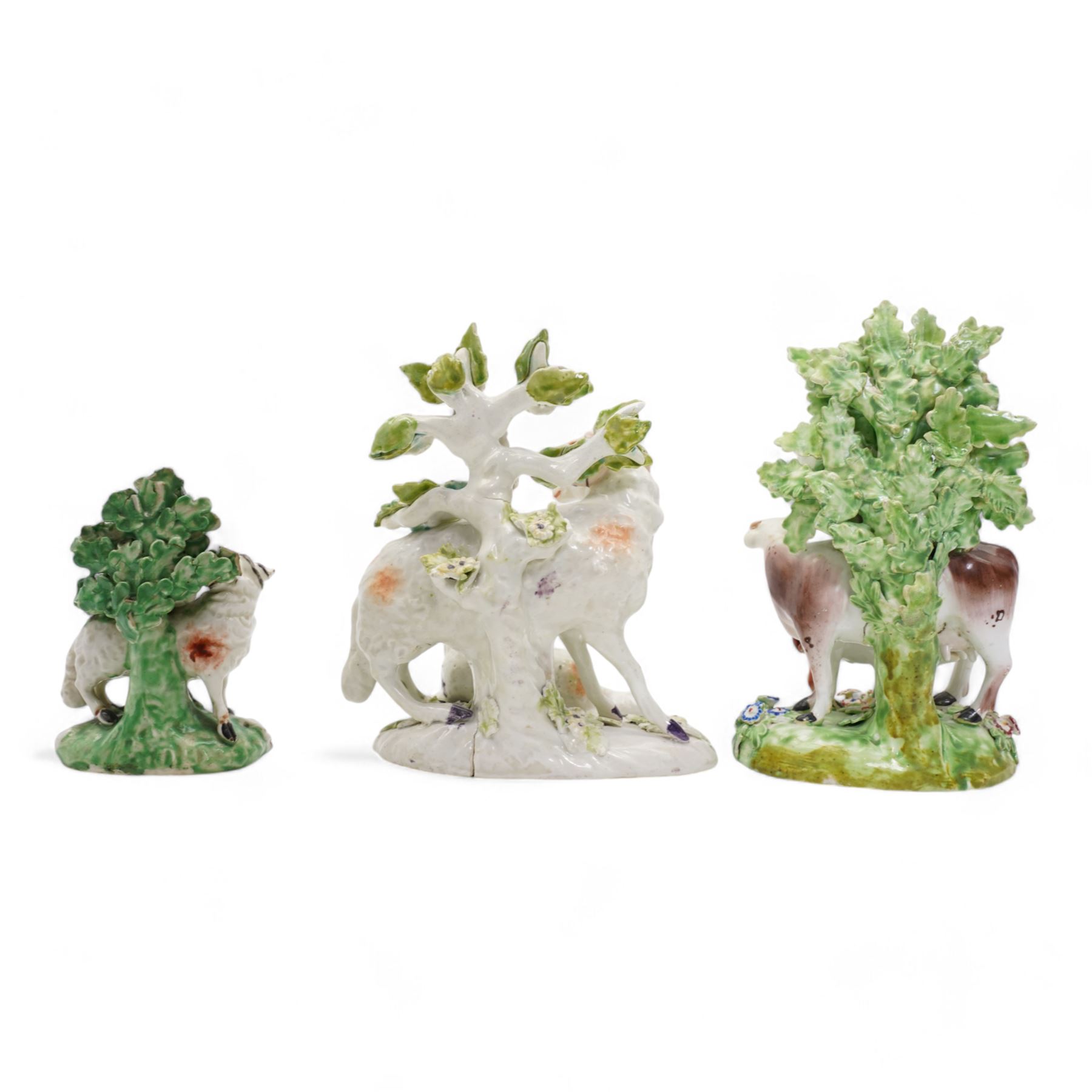 Two 18th century Derby porcelain groups modelled as a ram standing before bocage above a recumbent lamb, upon flower encrusted base, H15cm and two further Derby figures modelled as a ram and cow and calf (3)