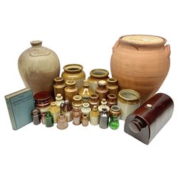 Large terracotta twin handled jar, of baluster form with wooden cover, together with a two gallon stoneware flagon, two green glass bottles, an Earthenware Collectors reference book and a collection of other stoneware jars and bottles
