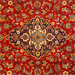 Central Persian Kashan hand-knotted carpet, central field in a ruby red ground with an indigo medallion with pendant motifs, enclosing scrolling arabesques, palmettes, and floral sprays in shades of indigo, turquoise, ivory, and gold, framed by indigo spandrels and a broad floral border between multiple guard stripes 