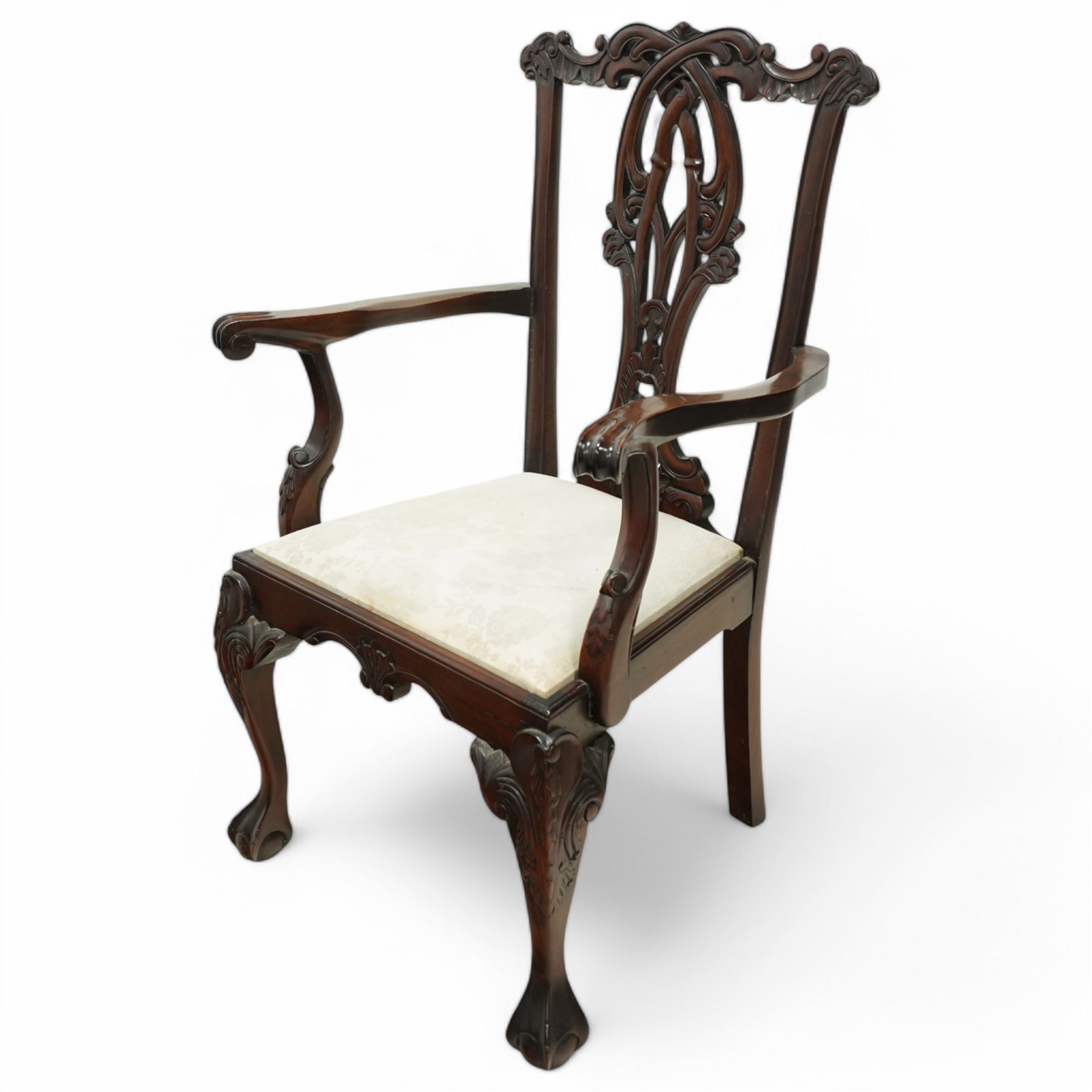 Chippendale revival mahogany dining chairs, set of six including a pair of carvers, the backs with intricately carved pierced splats beneath serpentine cresting rails, on acanthus carved cabriole front supports terminating in claw and ball feet, with cream upholstered drop-in seats