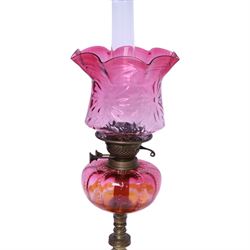 Victorian oil lamp, the brass base supporting cranberry glass reservoir, with clear glass chimney and cranberry shade with fluted rim, overall H59cm