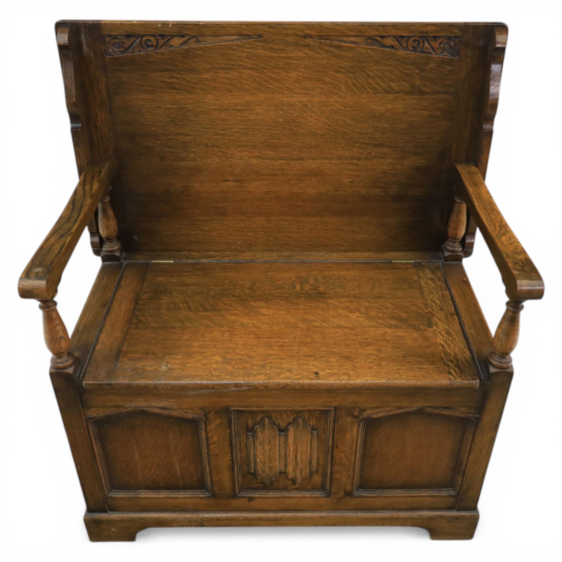 20th century oak monks bench with hinged box seat, with blind fretwork to the seat, panelled front and sides with linen fold panel in the centre