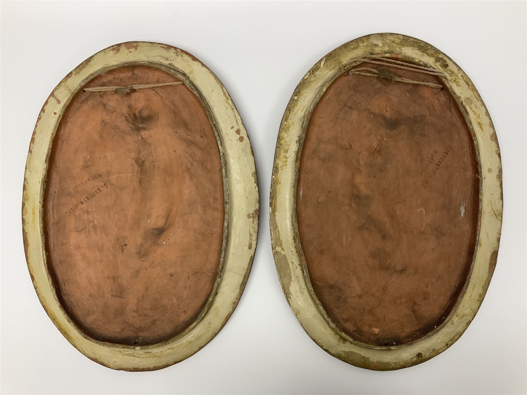 Pair of 19th century classical terracotta relief wall plaques depicting the goddess Hygeia and another goddess, seated holding an ewer, each of oval form, indistinctly signed, each stamped Ferreira verso, H42cm, W30cm