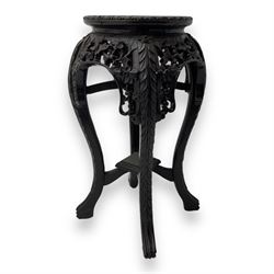 Late 19th century Chinese hardwood pedestal stand, circular top with inset marble panel, carved apron with openwork foliate and floral motifs, raised on cabriole supports with stylised claw and ball feet united by square undertier