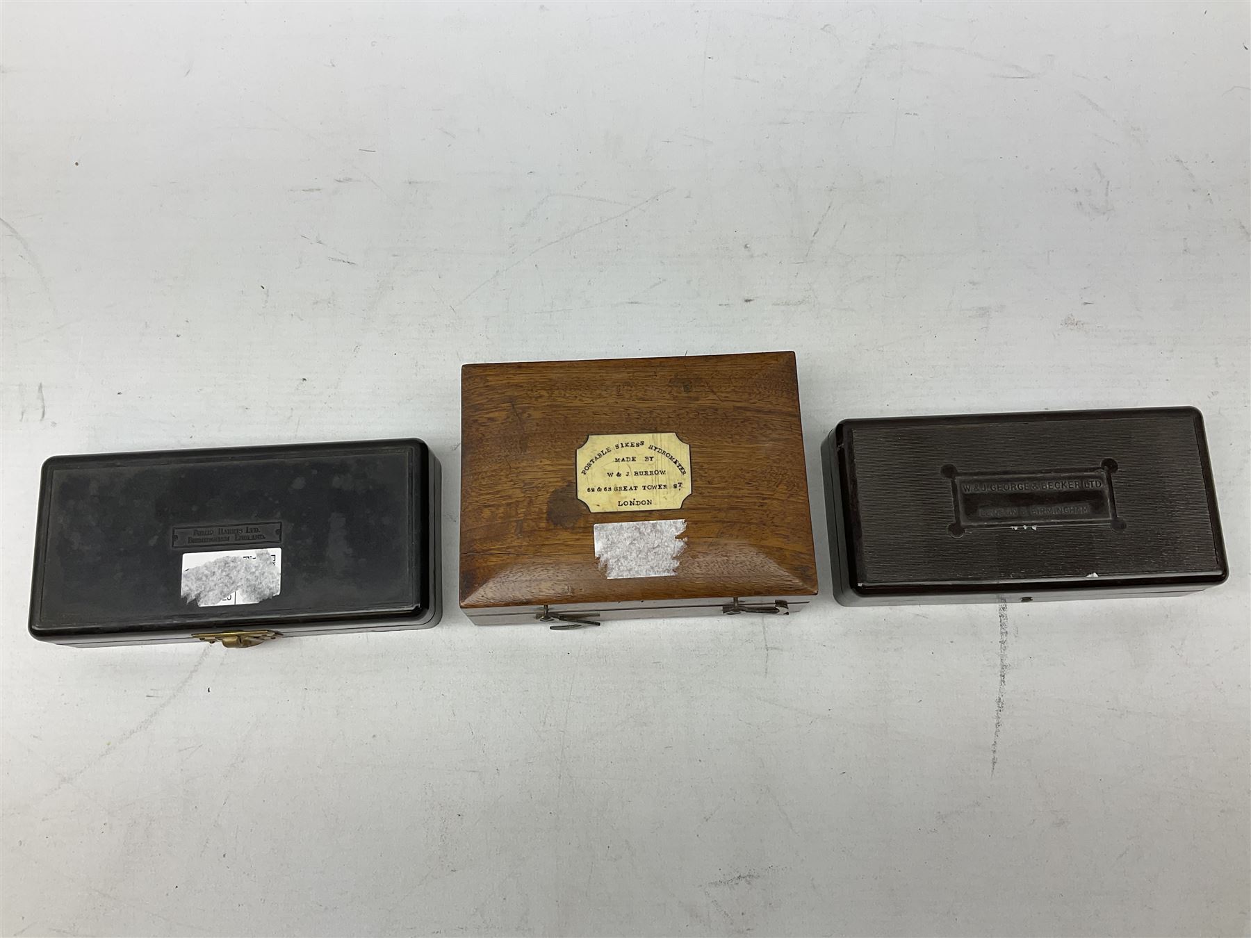 Victorian portable Sikes's hydrometer in original box, the hinged lid with inset plaque for W. & J. Burrow 62 & 63 Great Tower Street London, including ivory backed thermometer, W13.5cm; together with two bakelite cased sets of laboratory scales weights by W.J.George and Becker Ltd. and Philip Harris Ltd. (3)