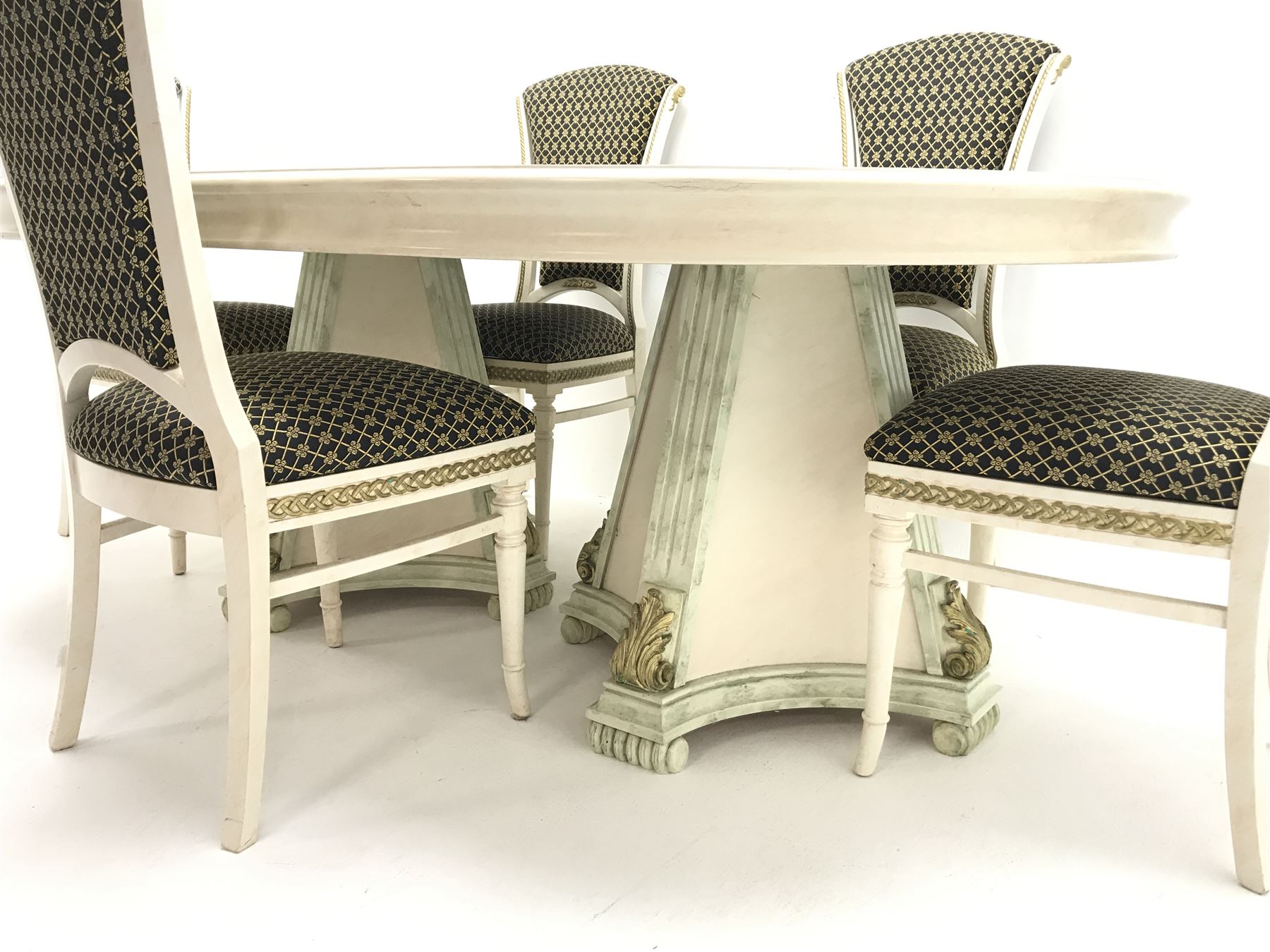 Italian style dining table, oval top with green marble finish spandrels, gilt scroll work and detail, central stepped lozenge motif, on two concaved square tapering pedestals with fluted uprights mounted with gilt acanthus scrolls (W198cm, H74cm, D130cm) and set five cream and gilt finished dining chairs, upholstered back and seat, turned tapering supports (W50cm)