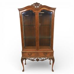 Queen Anne design walnut display cabinet, carved cartouche above two glazed doors enclosing two fixed glass shelves, over two frieze drawers above a heavily carved apron with cabriole supports