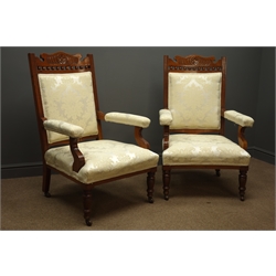  Pair Edwardian walnut framed drawing room arm chairs, carved floral cresting rail, upholstered back seat and arms in damask ivory, turned supports, W65cm  