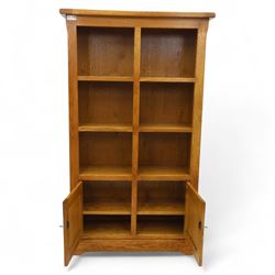 Old Charm - 'Chatsworth' light oak bookcase with two cupboards, featuring two fixed horizontal shelves forming six  rectangular open compartments, over twin panelled cupboard doors, chamfered uprights and plinth base
