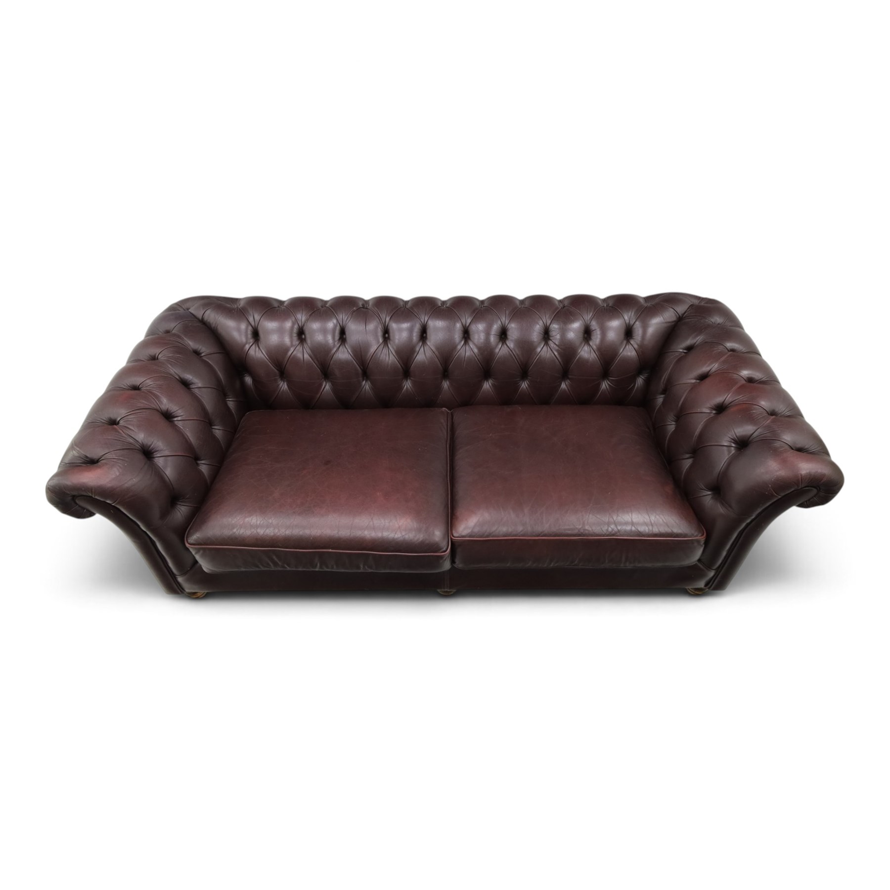 Thomas Lloyd - traditional shape Chesterfield two seater settee with rolled back and arms, upholstered in buttoned deep oxblood leather with loose seat cushions, raised on turned feet