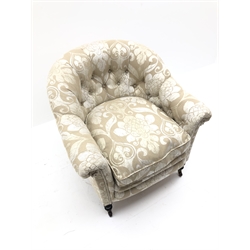  19th century tub chair with curved buttoned back, upholstered in champagne scrolled and flur de lys pattern, loose seat cushion, the ring tuned mahogany supports with brass and ceramic castors  