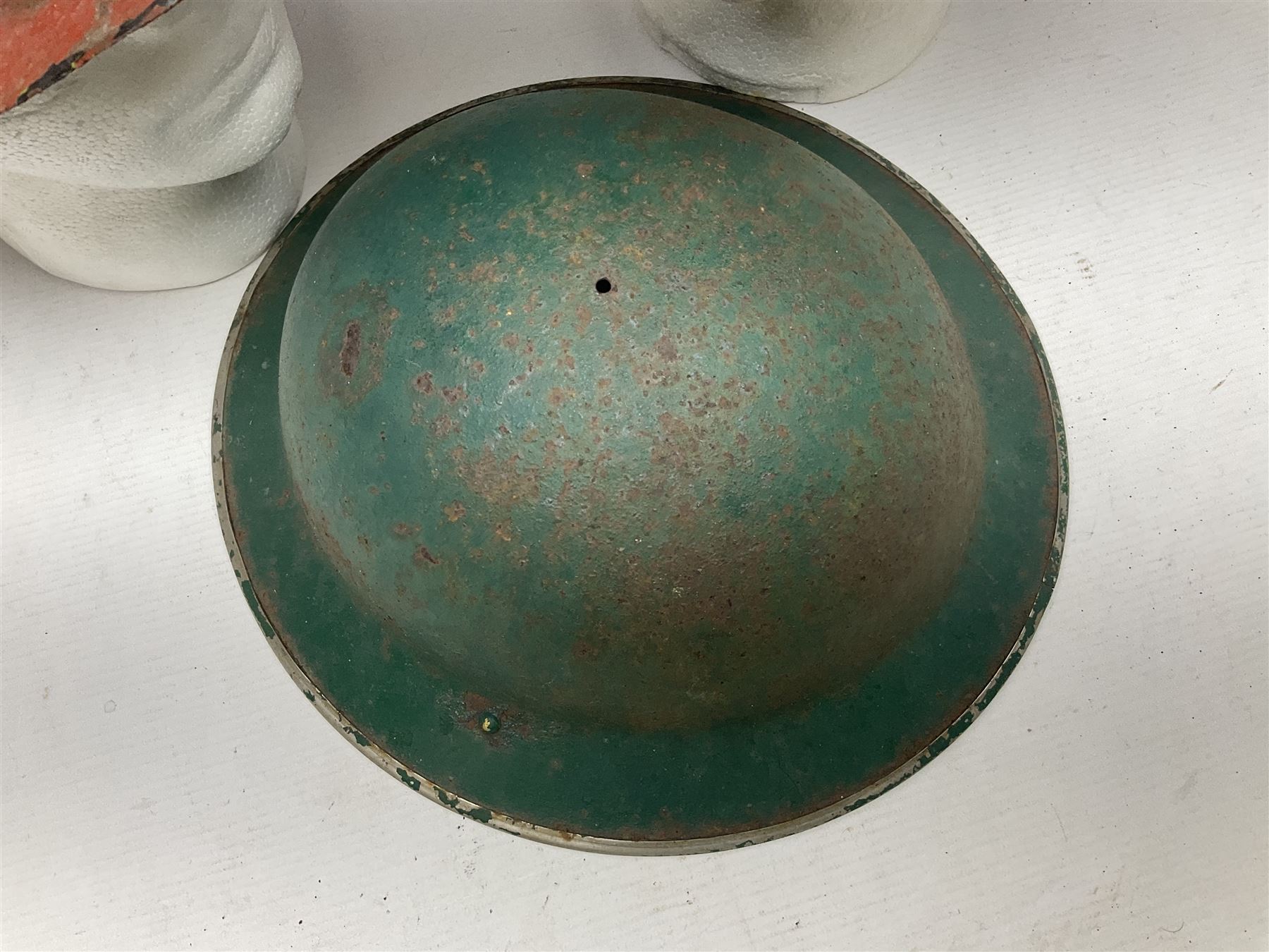 Three battlefield relic helmet shells - WWI German M16; WWI French Adrian; and WWII British (3)