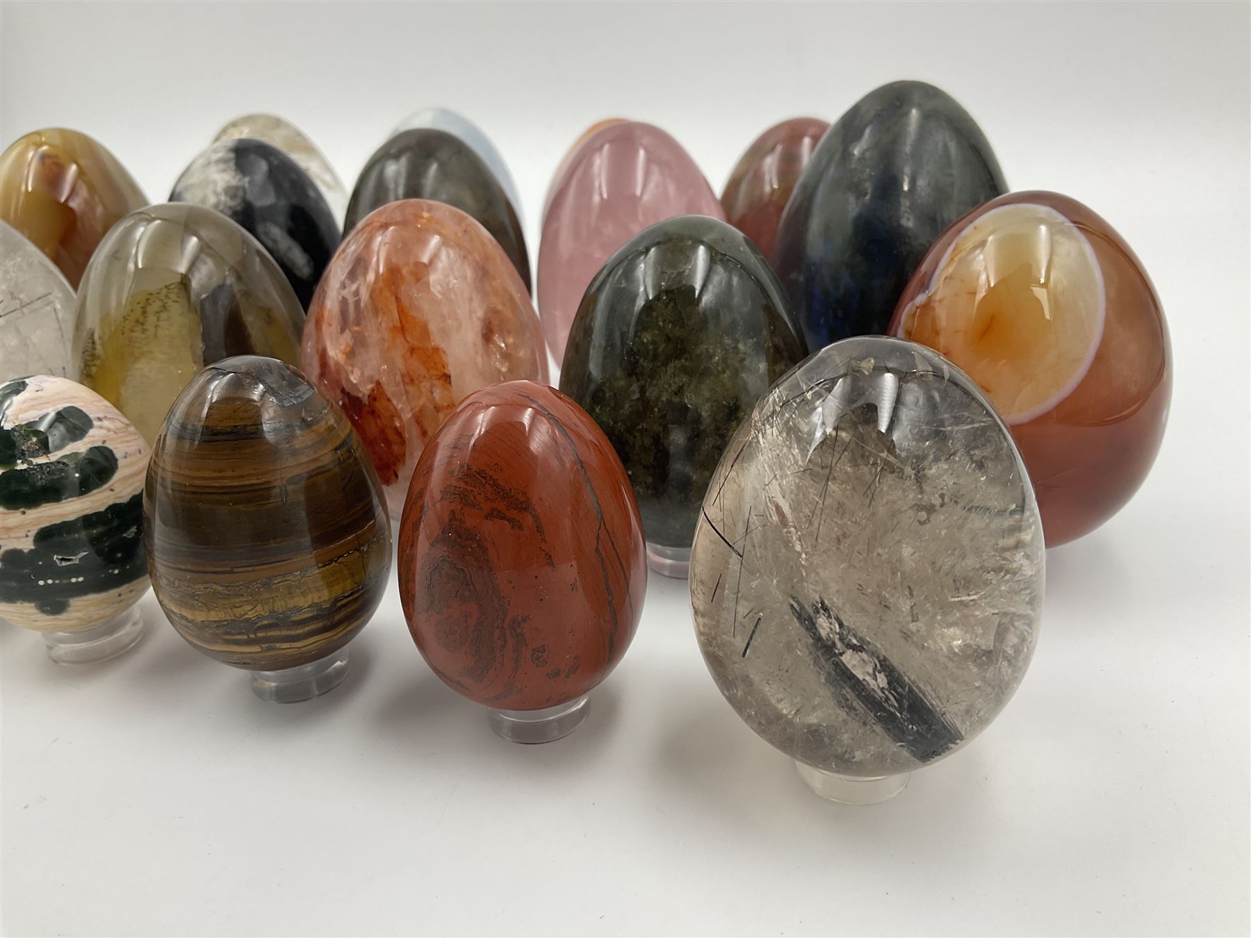 Collection of twenty-one hardstone specimen eggs, including labradorite, calcite, orbicular jasper, tiger's eye, smokey quartz, fossilised wood etc, originally part of the collection of the late Stanley J Seeger