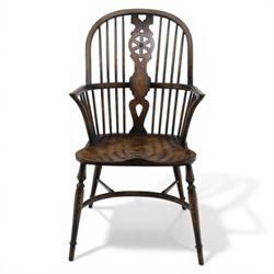 Late 19th century elm and beech high back Windsor armchair, the arched hoop back centred by a pierced wheel splat above a heart shaped lower piercing, with turned spindles and shaped arm rail, saddle seat, raised on turned legs united by a crinoline stretcher