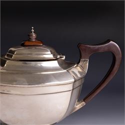 Art Deco three-piece silver tea service, comprising teapot with removable tea strainer, open sucrier and milk jug, all of hexagonal form, the teapot with wooden handle and finial, all hallmarked James Deakin & Sons, Sheffield 1925, together with a matched pair of silver sugar tongs, hallmarked
