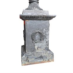 Pair of Victorian cast iron campana form garden urns, the gadrooned flared edge over a scrolling acanthus relief body, with twin male mask handles to each side, over a lobed underbelly with fluted socle, the rectangular pedestals with relief floral garlands and stepped base, in rustic black-painted finish, planted