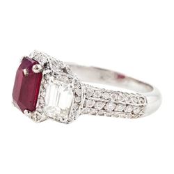 18ct white gold ruby and diamond trilogy ring, single emerald cut ruby of approx 1.85 carat, with a single emerald cut diamond set either side, all surrounded by round brilliant cut diamonds, the shoulders set with three rows of round brilliant cut diamonds, principal two emerald cut diamonds approx 1.10 carat
