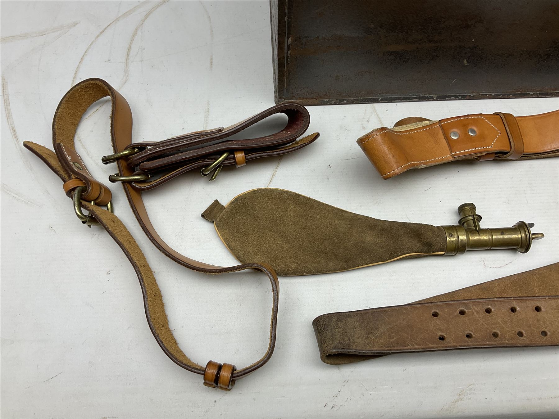 Assorted militaria including ten leather or canvas cartridge and other belts, maroon beret with 17th Lancers cap badge, modern bullet mould, leather and brass shot flask, two knives, shell cases, boomerang etc; in tin deed box