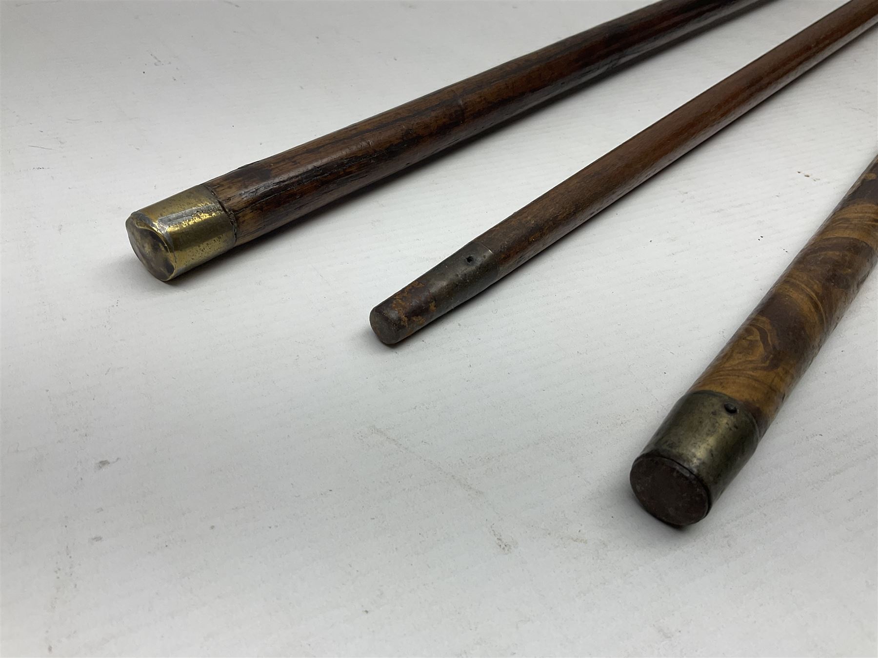 Three early 20th century walking sticks, to include a smoking pipe walking stick, the cane opening to reveal a concealed pipe, and a wooden walking cane, the metal cover with inscription 'bell metal and wood of York Minster, Burnt May 20 1840, and a turned wooden walking stick, with marquetry checkerboard pommel, tallest L90cm
