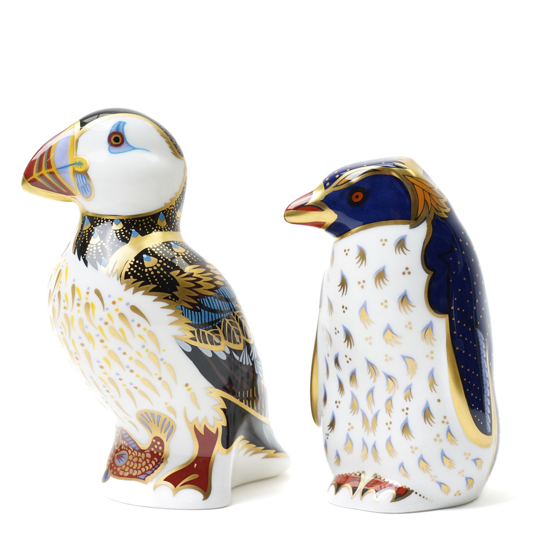 Three Royal Crown Derby paperweights, comprising Puffin with gold stopper, Rockhopper penguin with gold stopper, and Penguin and Chick with gold stopper, two with boxes (3)